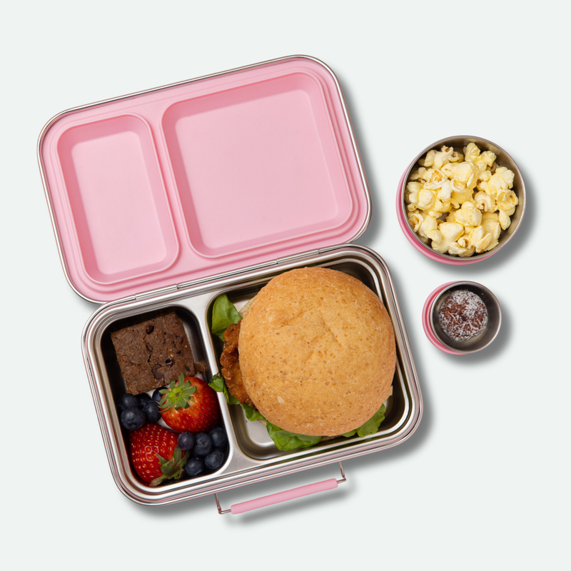 leak proof two compartment stainless steel lunch box with light pink silicone seals and lid and clasp full of food
