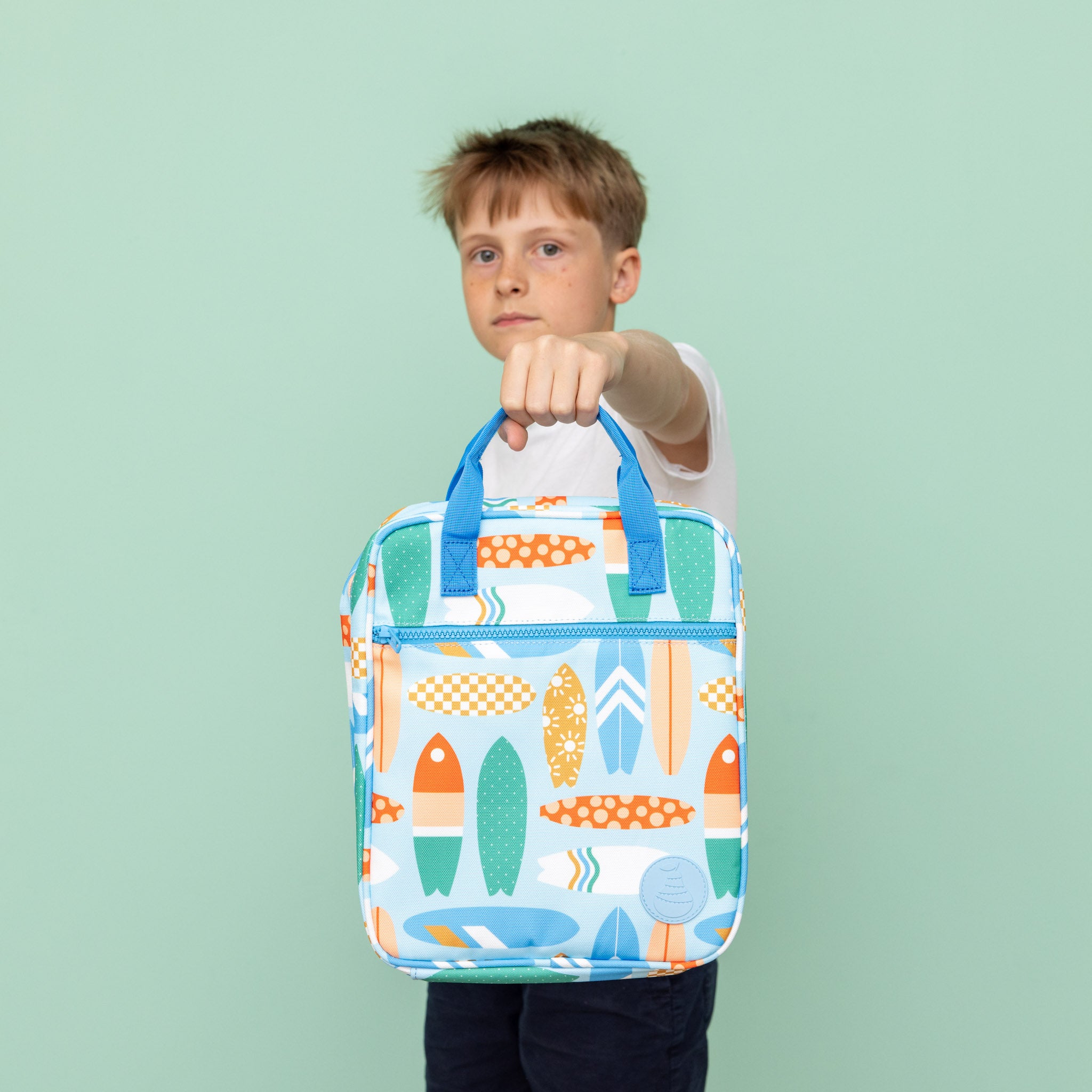 jumbo sized lunch bag with vintage surfboard print being held by child