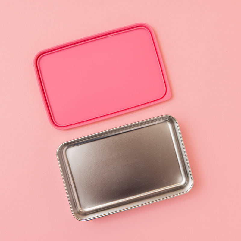 large stainless steel salad container or lunch box with dark pink  silicone lid on pink background empty 