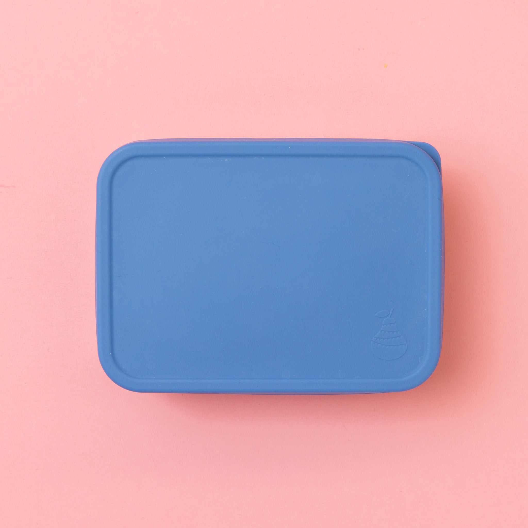 rectangular stainless steel container with silicone blue lid on a pink background