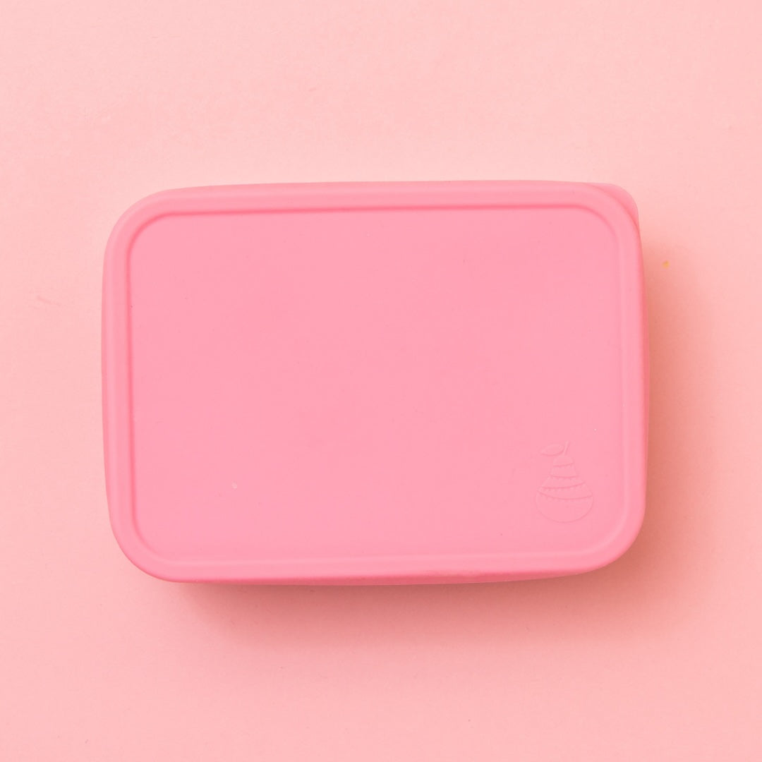 stainless steel snack container with pink silicone lid on showing pear logo embossed on lid 